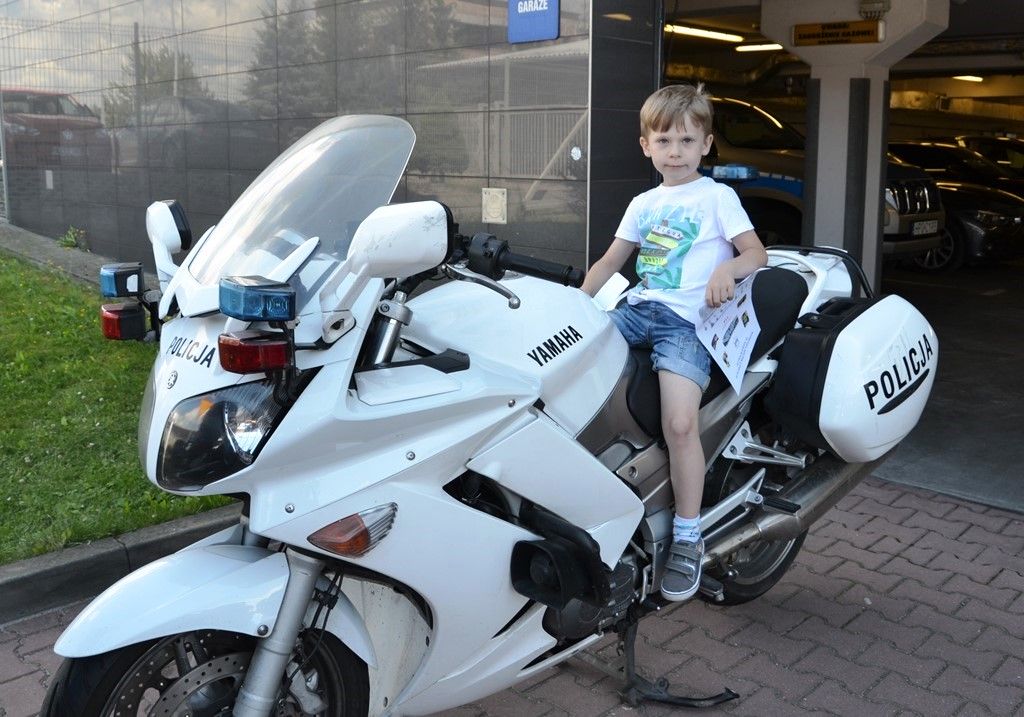 chłopiec siedzi na policyjnym motocyklu
